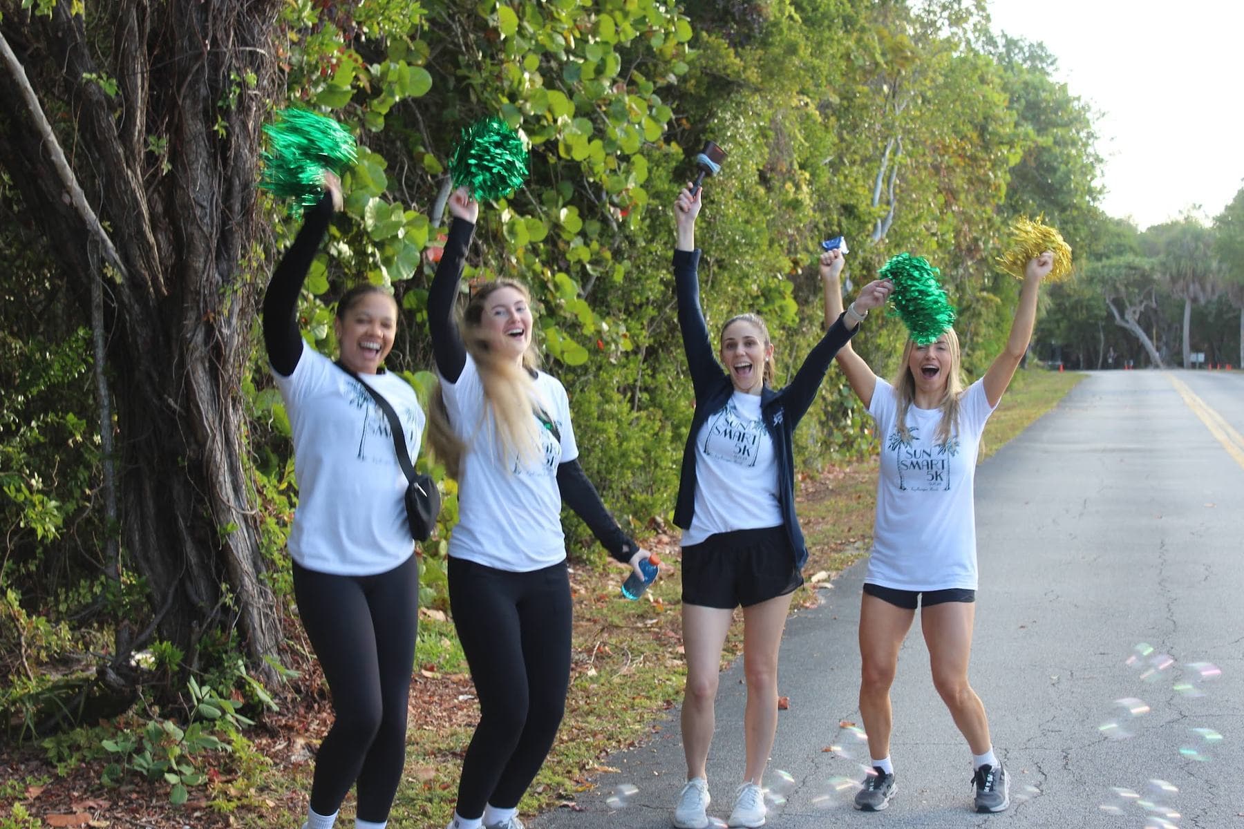 Volunteers cheering with pom-poms along the course