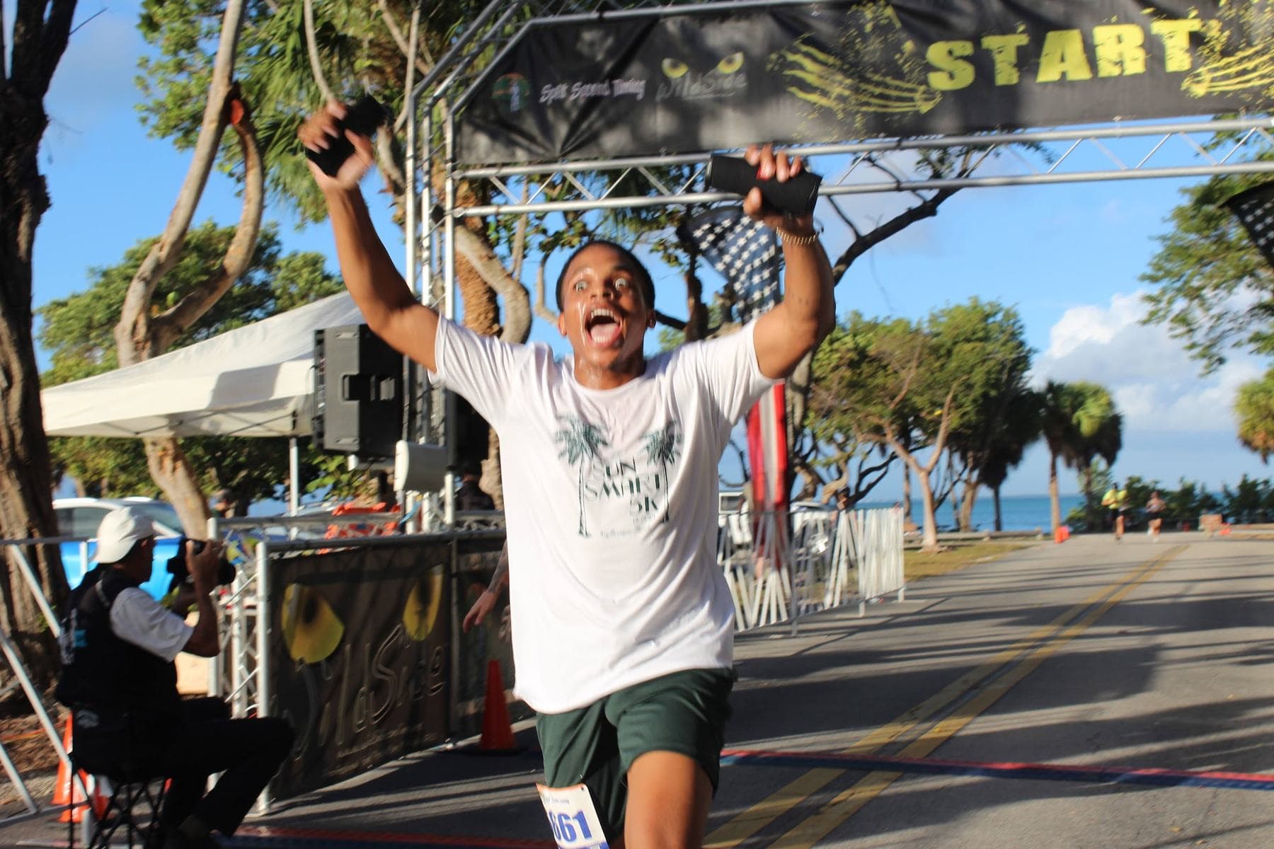 A runner with both arms up crossing the finish