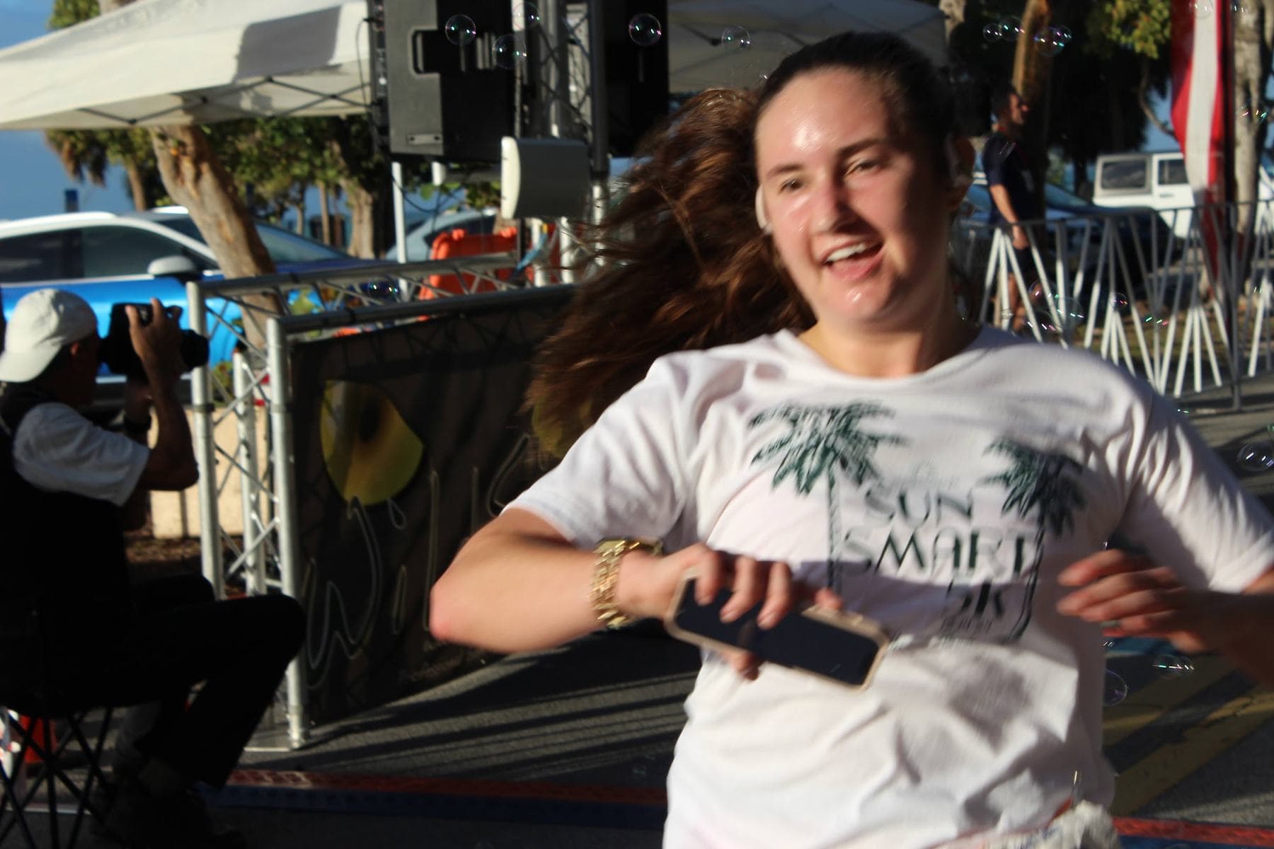 A runner smiling as she reaches the finish
