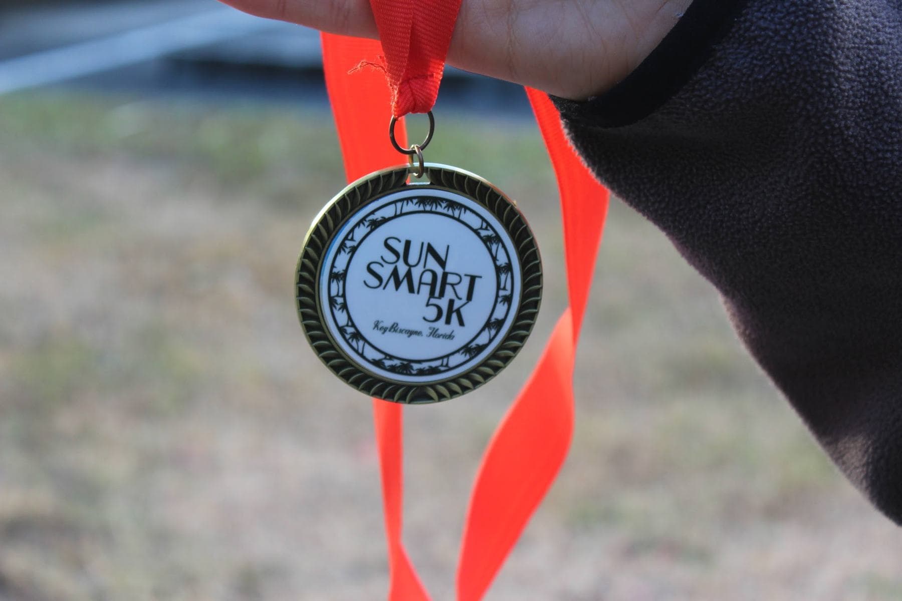 A SunSmart 5K finisher medal held up close
